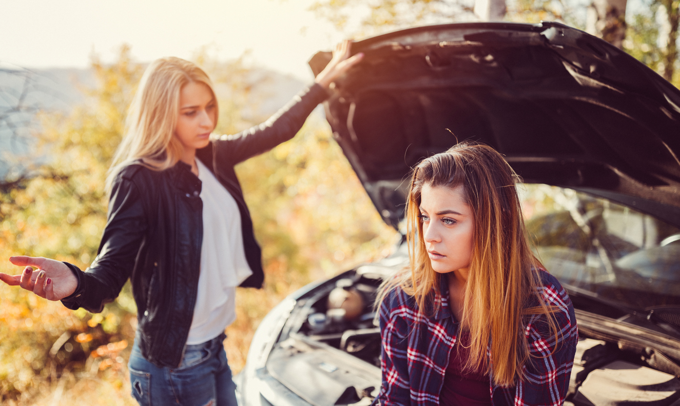 Young girls experiencing problems with broken down car