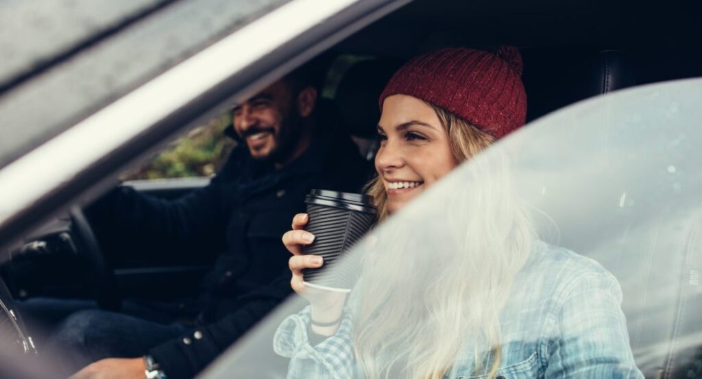happy couple on a winter road trip into a carbar subscription vehicle
