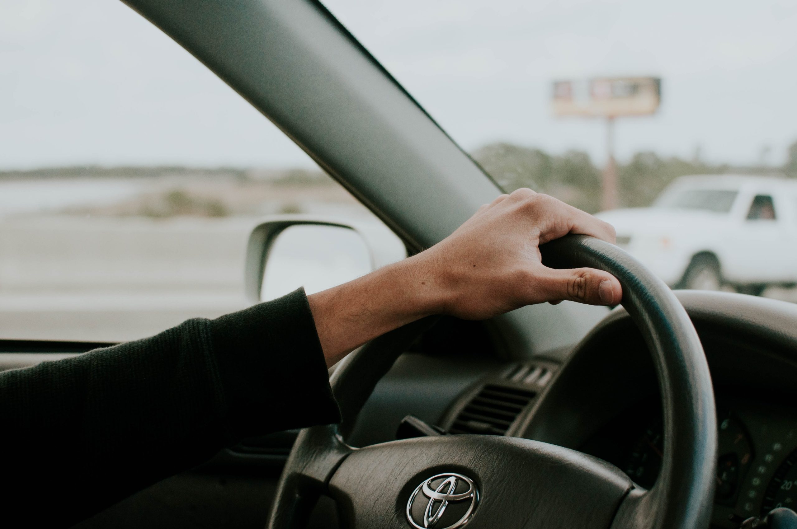 male hand on Toyota steering wheel