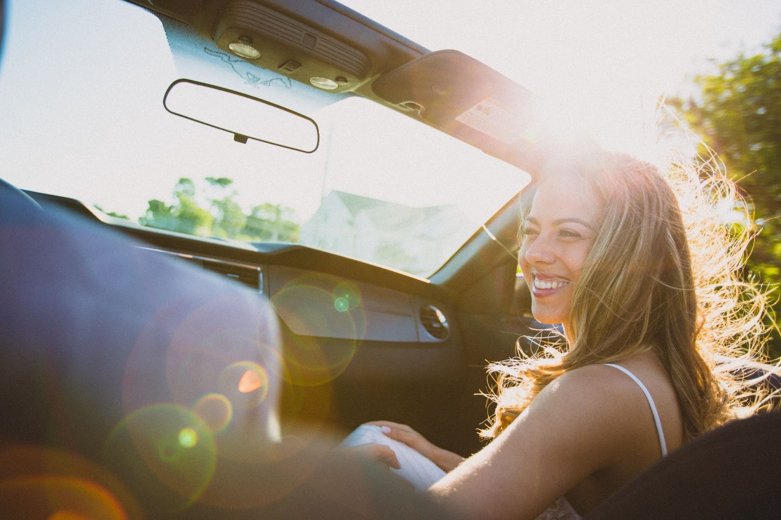 young happy woman in a car subscription vehicle